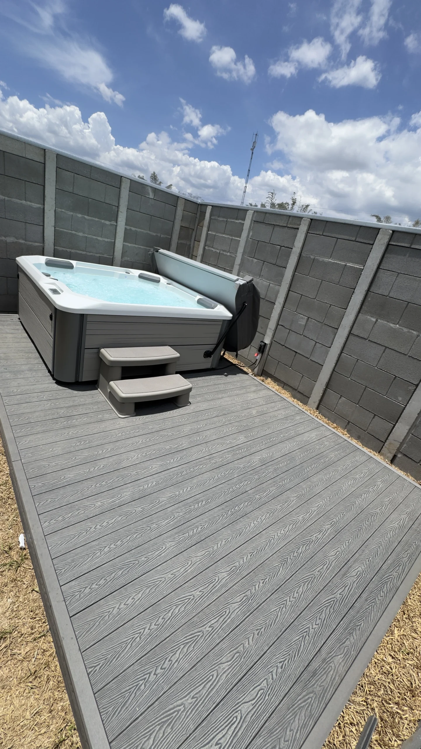 Deck WPC gris instalado junto a un jacuzzi