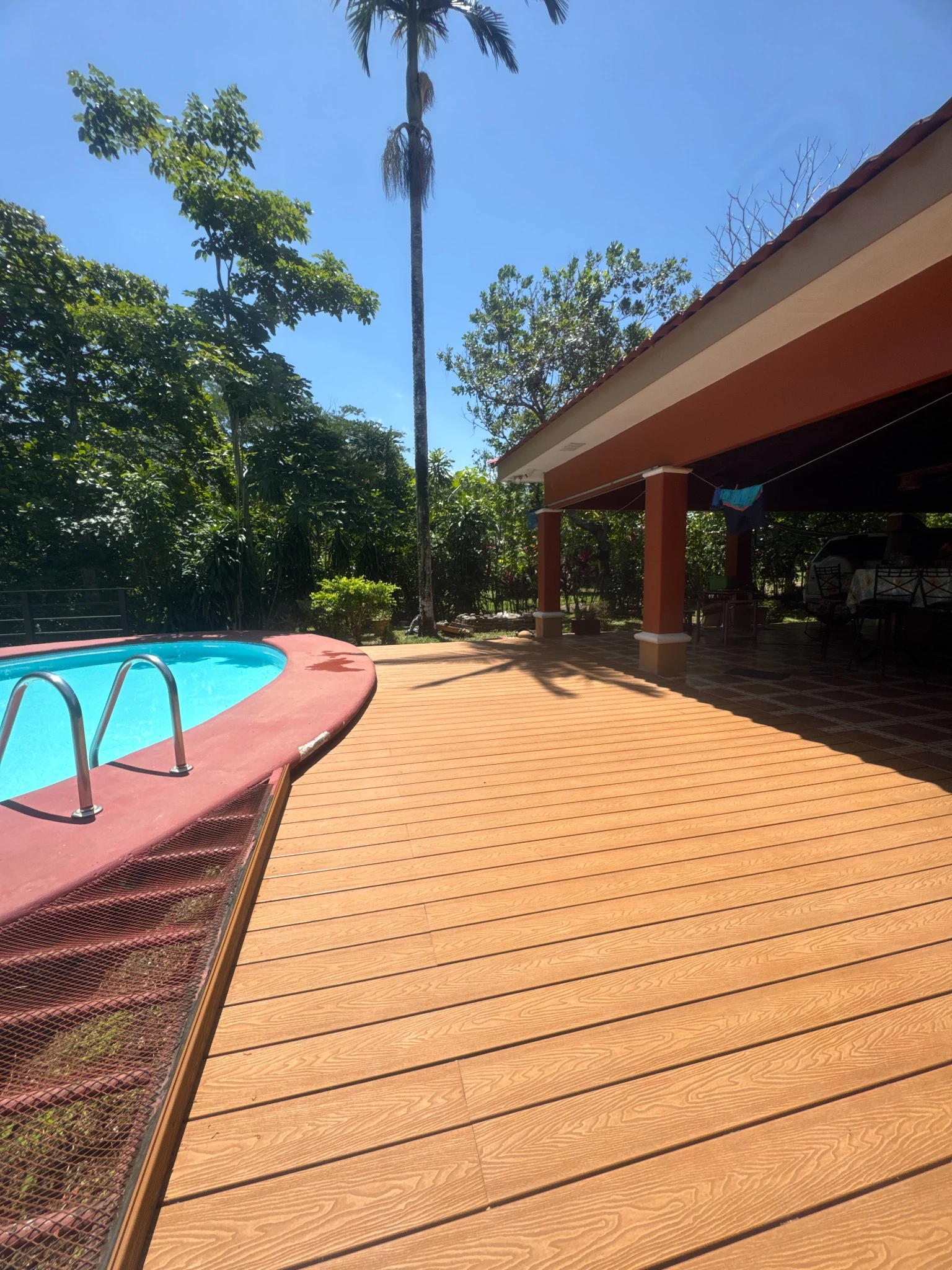 Amplia terraza de Deck WPC junto a una piscina
